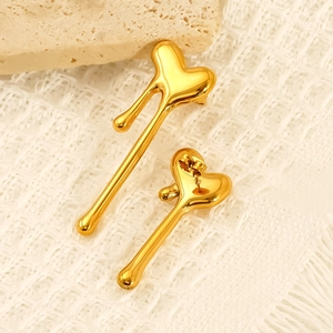 Polished gold-plated melting heart stud earrings in 18k stainless steel on a textured stone