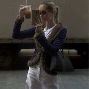 Detail of dark blue slim fit cardigan featuring brown faux fur trim and V-neckline