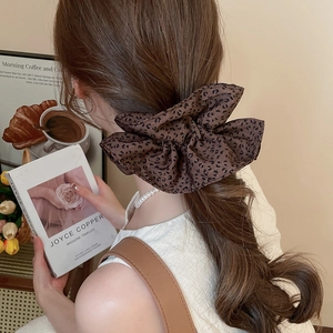 Leopard print fabric scrunchie shown in hair for a stylish ponytail look on a model