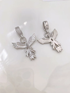 Detail view of twin angel wing star pendants with silver finish and inlaid rhinestones