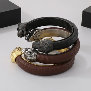 Detail of men's leather bracelets with metallic lion head charms and various textures