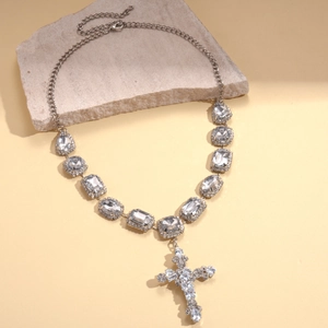 Detail of silver chain necklace with geometric crystals and a sparkling cross pendant