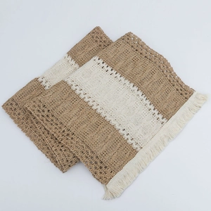 Detail of jute and lace placemat with woven fringe edges and dual-tone rustic texture