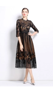 Détail d'une robe en dentelle noire ajourée avec doublure camel et bords festonnés