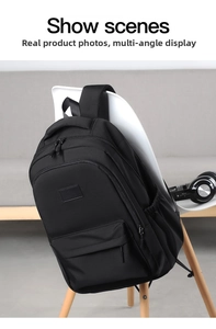 Detailed view of black student backpack with multiple zipper pockets on a chair