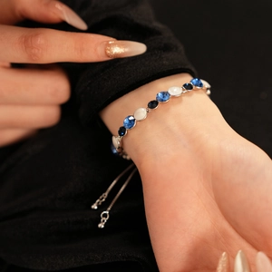 Gros plan du bracelet perlé argenté ajustable avec des cristaux bleus et blancs brillants