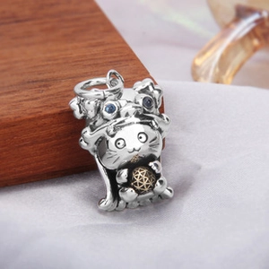 Détail macro du pendentif chat en argent avec tête de lion et yeux en pierres bleues