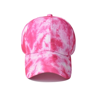 Detailed view of pink and white tie-dye cotton fabric texture on a fashion baseball cap