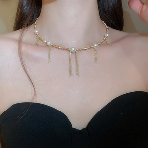 Close-up of French style pearl tassel necklace with gold chains on neck