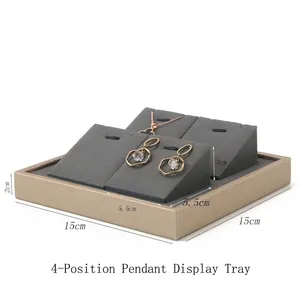 Gray jewelry tray detail with four slots for pendant and earring display on a gold frame