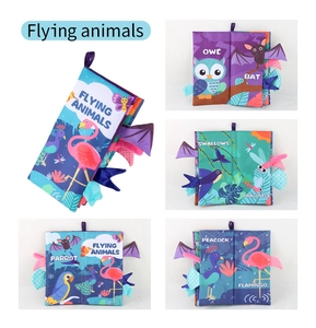 Detail of baby cloth book showing colorful flying animals and 3D sensory elements