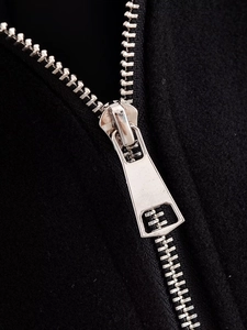 Detail of high-quality silver metal zipper on premium black woolen jacket for women