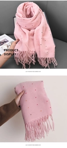Detail of pink imitation cashmere scarf featuring colorful polka dots and fringe tassels