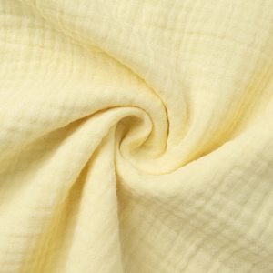 Close-up of yellow breathable double gauze cotton fabric with soft muslin texture