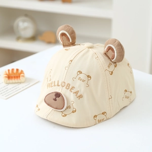 Dettaglio del basco in cotone beige con orecchie di orso e ricami carini per bambini
