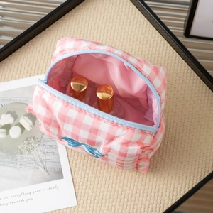 Pink checkered makeup bag with blue zipper and internal cosmetic storage display