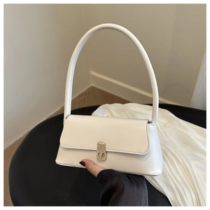 Close-up of cream-colored faux leather underarm bag with elegant gold metal clasp