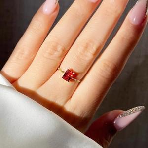 Close-up of a 18K gold-plated adjustable chain ring featuring a rectangular red zircon