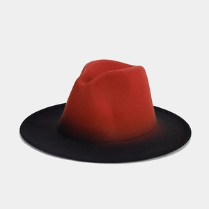 Close-up of red and black gradient wool felt fedora showing a wide brim and soft texture