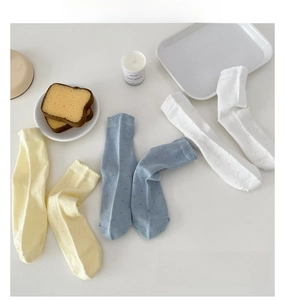 Flat lay view of three-color pointelle cotton socks in beige blue and ivory white
