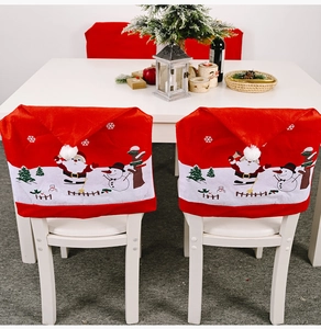 Detailed view of red Christmas chair covers with Santa and snowman patterns for dining decor