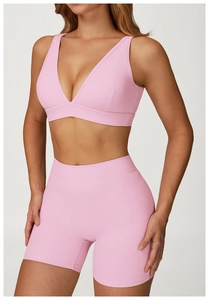 Vue détaillée d'un ensemble de yoga rose avec brassière col en V et short de sport