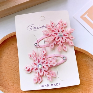 Close-up of pink glitter snowflake hair clips with rhinestone on handmade card display