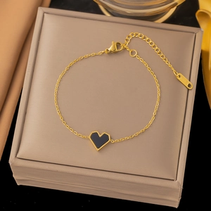 Nahaufnahme der Goldkette mit schwarzem Herzanhänger und K18-Etikett auf Schmuckbox