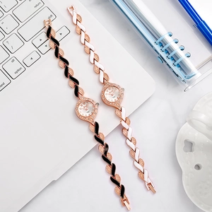 Dettaglio di orologi da donna in oro rosa con strass su sfondo tastiera PC