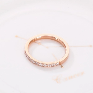 Detail eines Roségold-Rings mit Zirkonia auf einem weißen Cancer-Sternzeichen-Teller