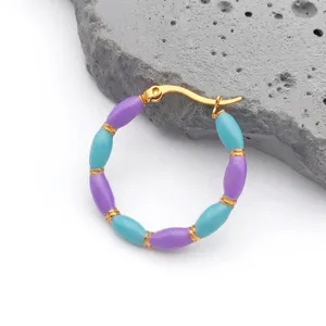 Detail of bohemian hoop earrings with blue and purple beads and gold-plated bamboo accents