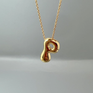 Detailed close-up of a 3D gold initial P pendant on a delicate matching link chain