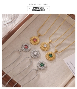 Detail shot of sunflower necklaces in gold and silver with red, white, and green gemstones