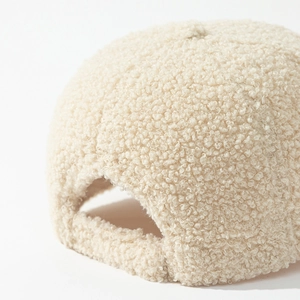 Detailed macro shot of the beige lamb wool baseball cap texture and back adjustment strap