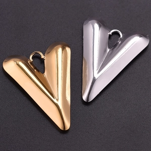 Chic 304 stainless steel heart pendants in gold and silver finish on textured surface