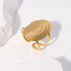 Detailed macro view of gold wide band ring with bohemian oval ripple textures
