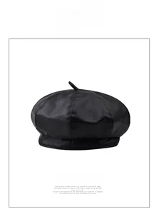 Detail view of stitched paneling and texture on a glossy black leather beret hat