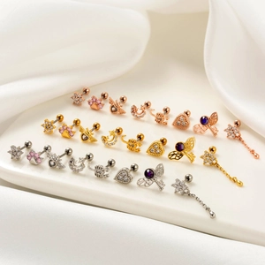 Detailed collection of assorted cartilage studs with star and flower designs on silk