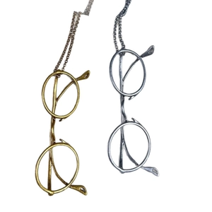 Retro style eyeglass pendant necklace in antique gold and silver finishes on white background