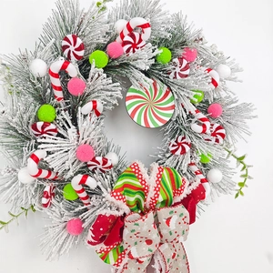 Detailed close-up of Christmas candy cane wreath with snow-tipped pine needles and bow