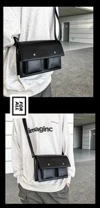 Detail of black crossbody bag with dual 3D front pockets and matte leather finish