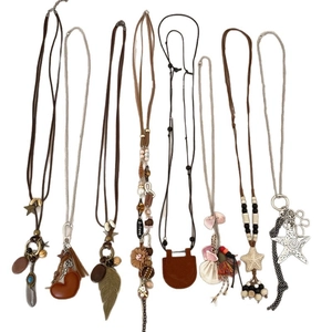 Set of bohemian style long necklaces with feathers, stars and wood beads on white background