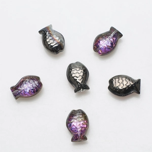Macro detail of six iridescent fish-shaped crystal beads for DIY jewelry making