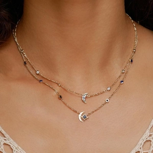 Retro gold double layer necklace with sapphire starburst and moon pendants on model