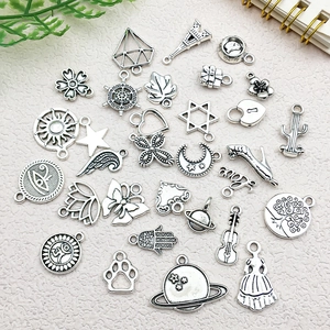 Detailed macro shot of vintage silver alloy charms featuring Eiffel Tower and celestial shapes