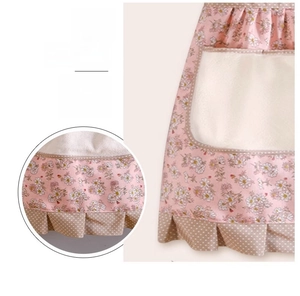 Macro view of the pink floral apron featuring elegant lace hem and polka dot pleats