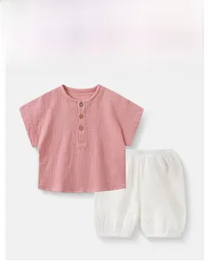 Detail of pink cotton gauze Henley top with wooden buttons and white shorts set