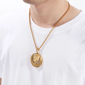 Close-up of hip-hop lion head pendant on gold chain worn by model on white shirt