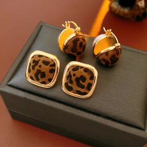 Detailed close-up of leopard print leopard earrings with golden frames and velvet flocking