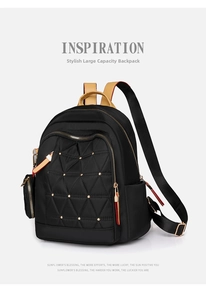 Detalle de mochila negra con remaches dorados y textura bordada de rombos acolchados
